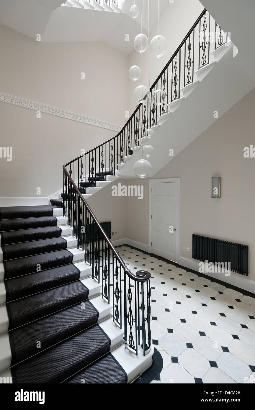 Ingresso con scalinata e in bianco e nero e pavimento piastrellato di bianco Foto Stock