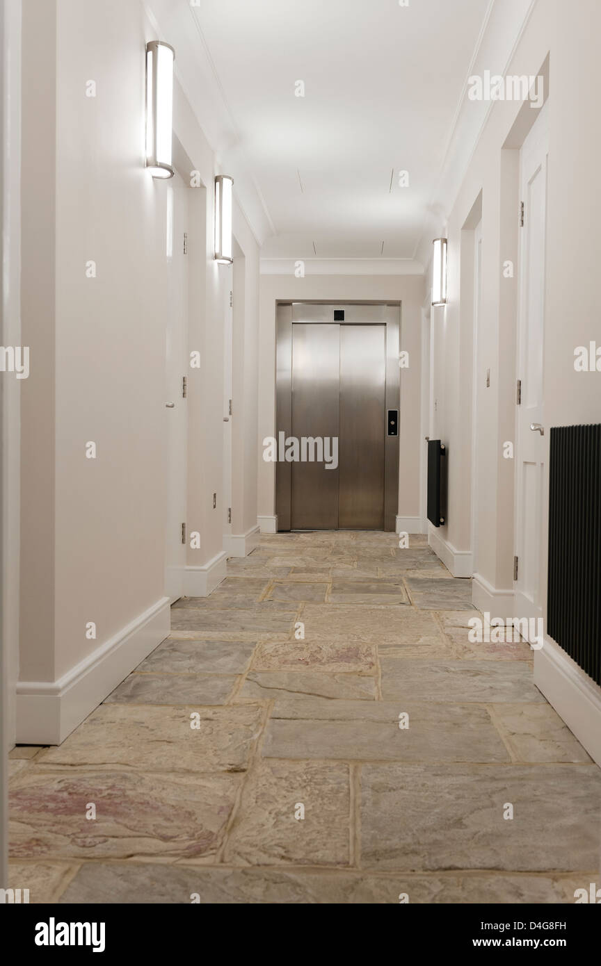 Svuotare il corridoio con pavimento in pietra e chiuso sollevamento metallico Foto Stock