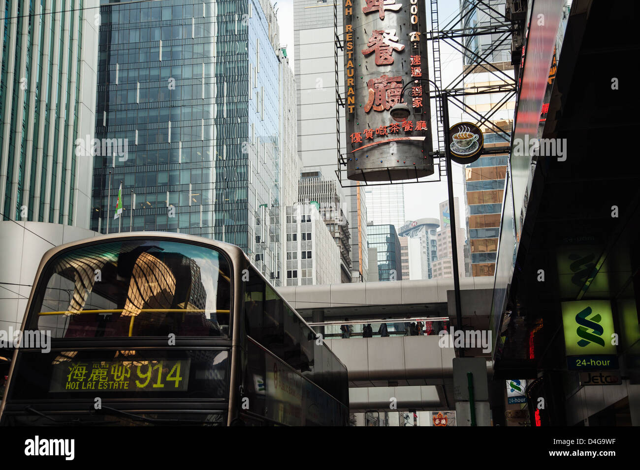 Un autobus di città, edifici moderni e un ristorante sign in Hong Kong. Foto Stock