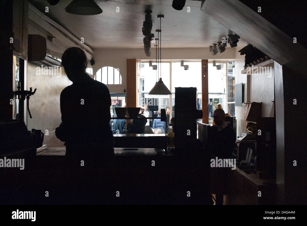 Londra, Regno Unito. Marzo 13. Un taglio di potenza hits Covent Garden. Un barista rende caffè filtro al buio a Monmouth Cafe, Monmouth Street, utilizzando acqua calda a sinistra in un'urna dopo una interruzione dell'alimentazione nel West End di Londra reso le macchine per il caffè espresso inutili. Regno Unito le reti di potere, l'organismo responsabile per la londinese di infrastrutture elettriche, detta la causa dell'interruzione dell'alimentazione è stato creduto per essere un guasto ad un cavo interrato. Credito: David Firn/Alamy Live News Foto Stock