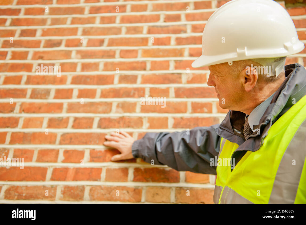 Edificio ingegnere controllando la muratura della parete esterna di un edificio. Foto Stock