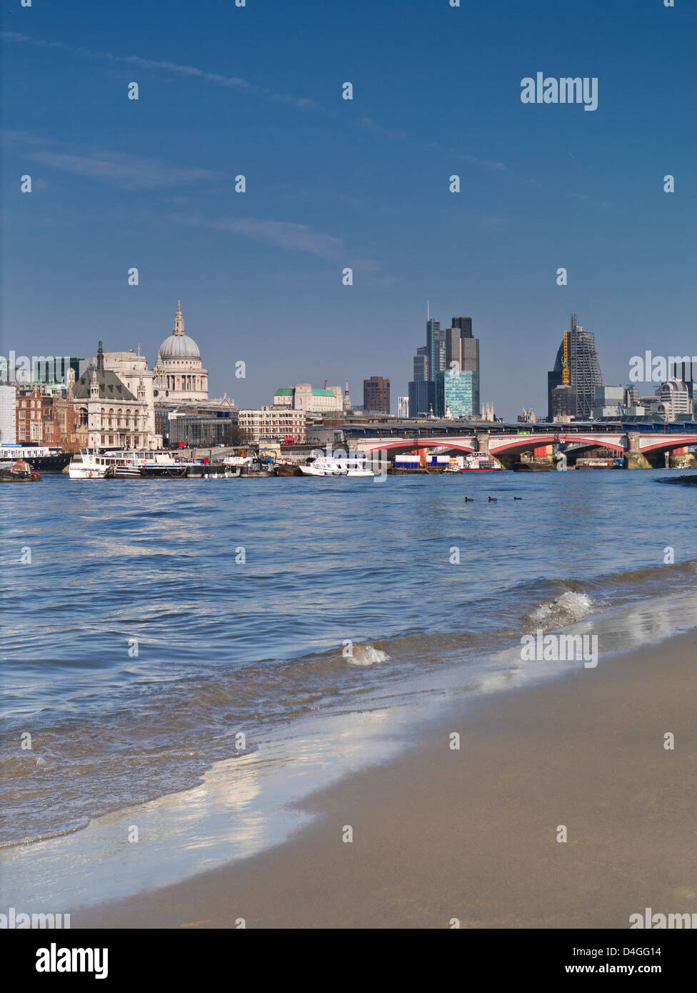 Città di Londra e San Paolo con calma il fiume Tamigi con la bassa marea rivelando calda pulita sandbank in primo piano London REGNO UNITO Foto Stock