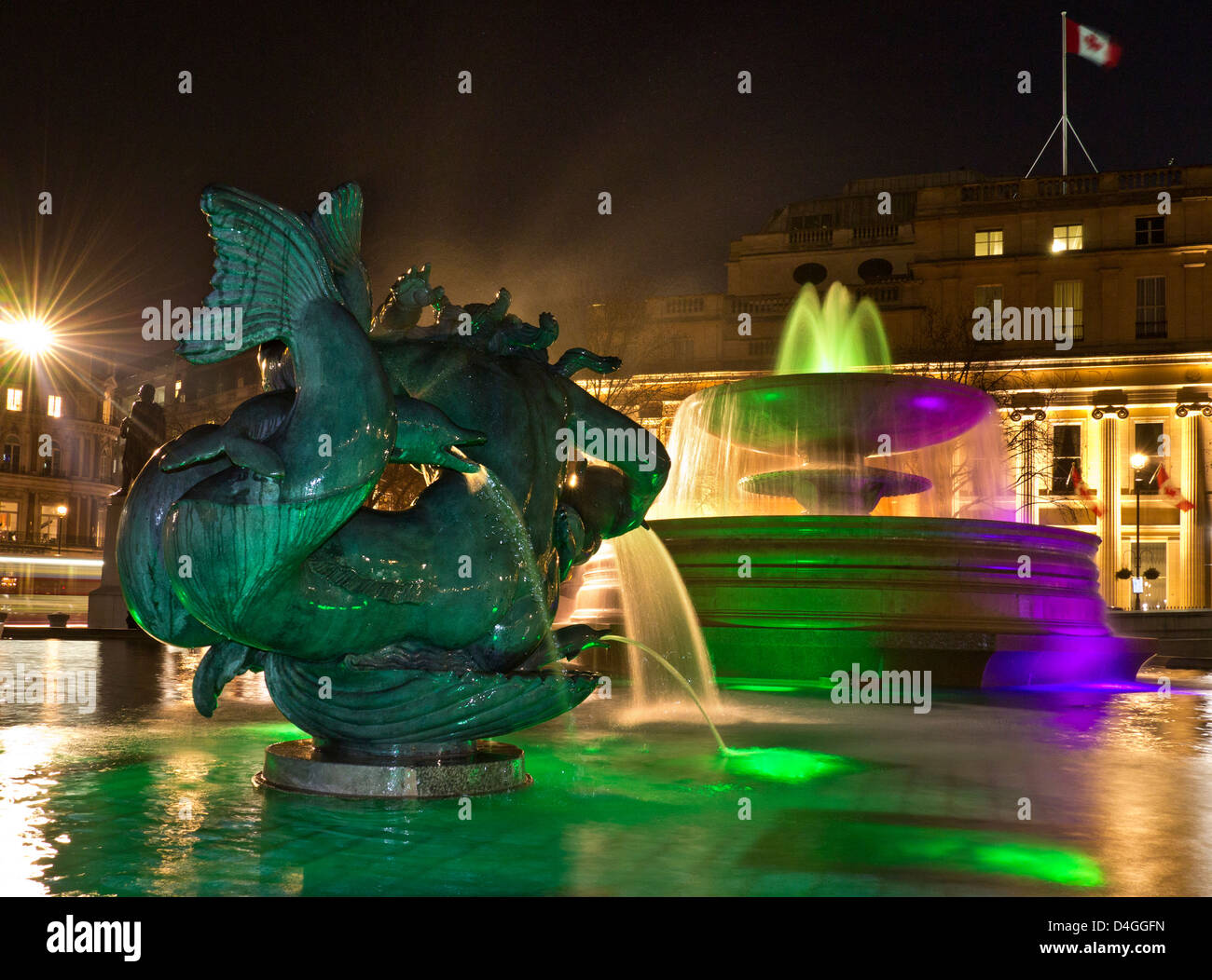 Trafalgar Square fontane illuminata di notte con il Canada House e bandiera dietro il West End di Londra REGNO UNITO Foto Stock