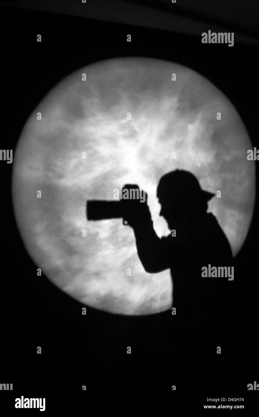 Silhouette di un uomo con una telecamera in Spotlight o al chiaro di luna (modello rilasciato) Foto Stock