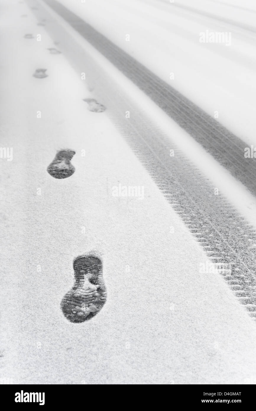 Impronte e tracce di pneumatici nella neve Foto Stock