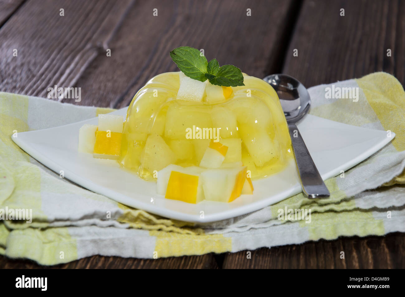 In casa di melata jella con pezzi di frutta su sfondo di legno Foto Stock