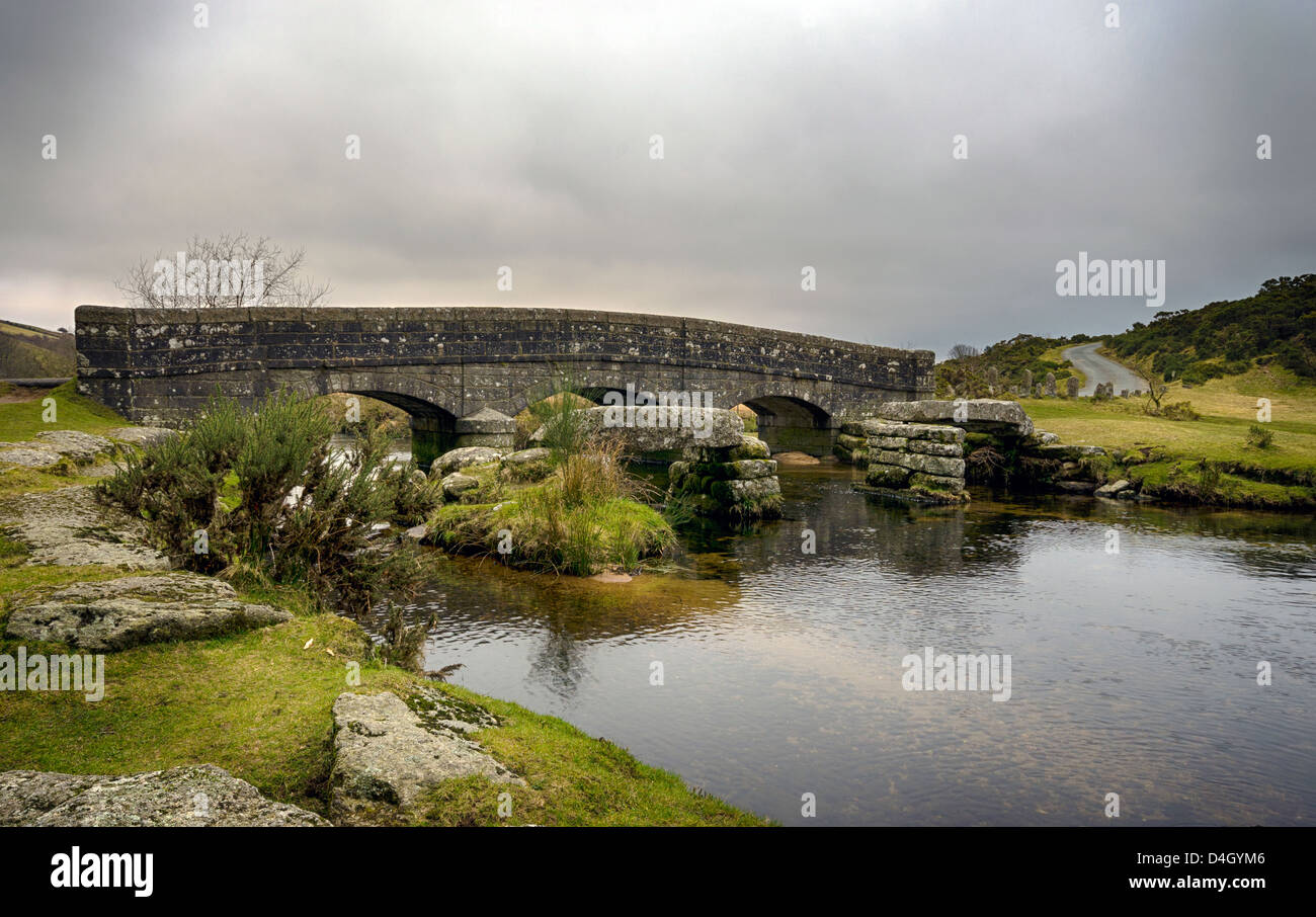 Un antico ponte di pietra con i resti di un antico granito battaglio ponte su un fiume nel Parco Nazionale di Dartmoor nel Devon. Foto Stock