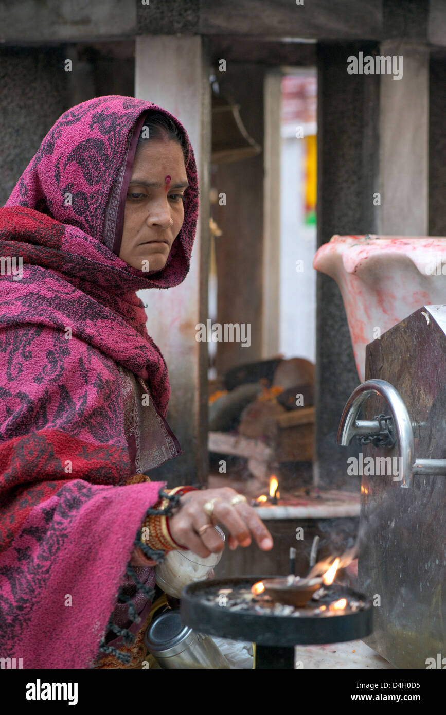 Una donna fa offerte di canfora in un tempio in Mathura, West Uttar Pradesh, India Foto Stock