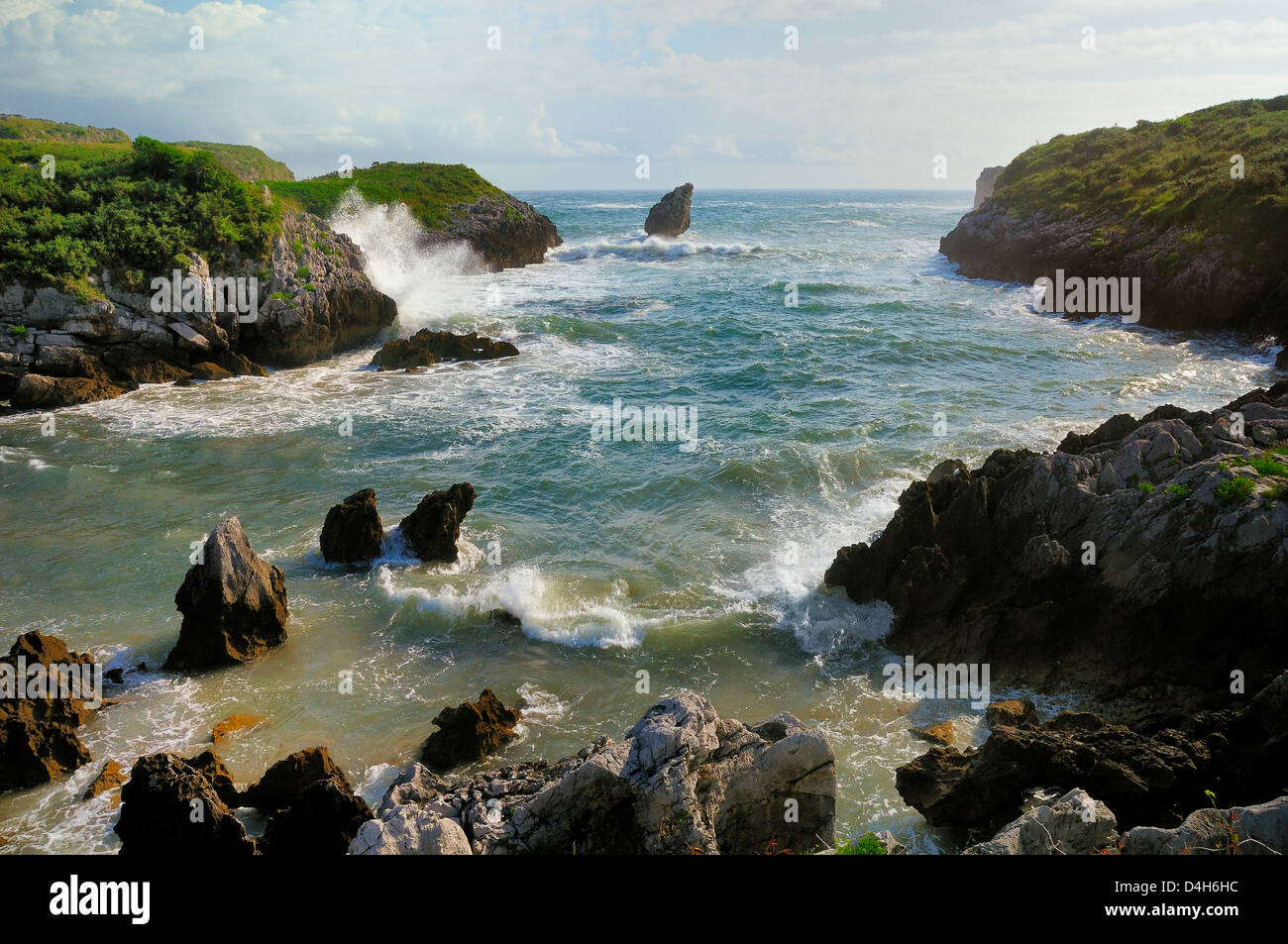 Buelna spiaggia e ambiente carsico El Picon pilastro di roccia ad alta marea in una giornata di vento, vicino a Llanes, Asturias, Spagna Foto Stock
