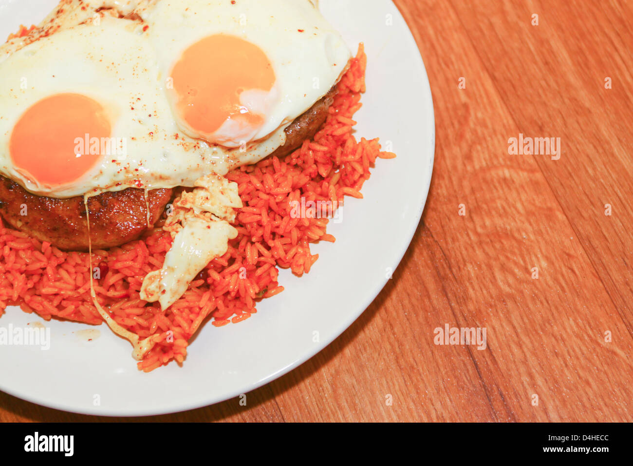 Beefburgers riso e uova fritte su piastra Foto Stock