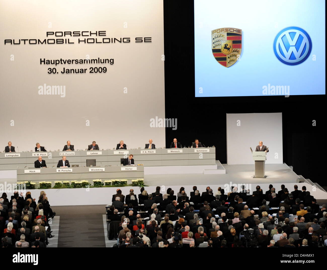 Wendelin Wiedeking (R), il CEO di Porsche, colloqui durante la riunione generale annuale presso Porsche Arena di Stoccarda, Germania, 30 gennaio 2009. Sul suo lato destro, una foto della sede centrale di Volkswagen sono proiettate sul muro. A causa della crisi auto, Wiedeking non vuole prendere impegni rigorosi in relazione all'acquisto di Volkswagen. Foto: Bernd Weissbrod Foto Stock