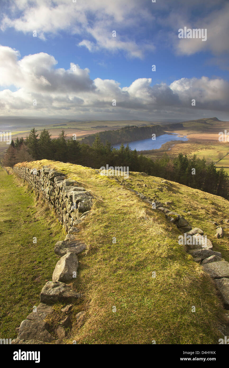 Il Vallo di Adriano dalla parte superiore della banca a caldo con balze Highshield sopra dirupi roccioso del Lough nella distanza Winshield dirupi. Foto Stock