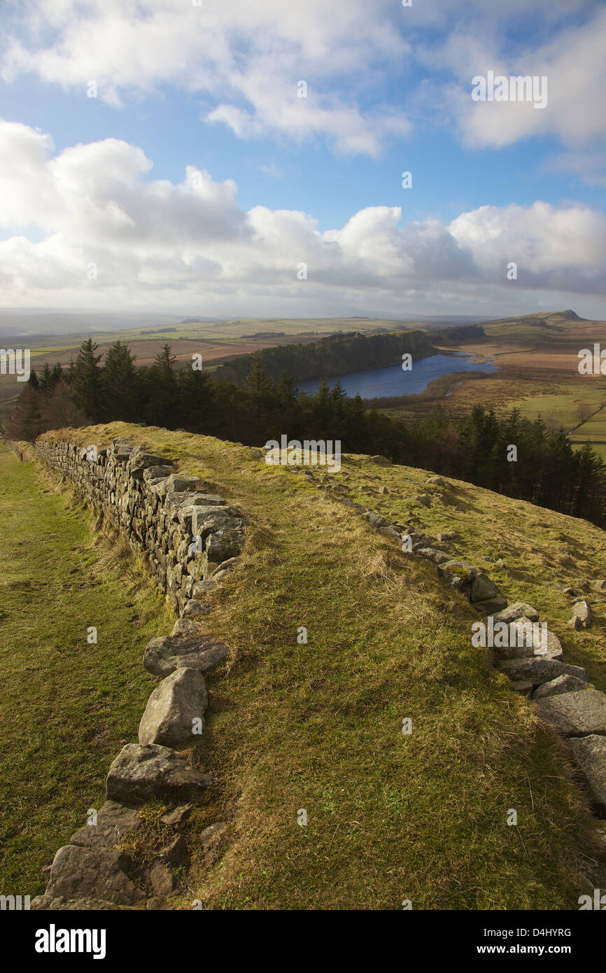 Il Vallo di Adriano dalla parte superiore della banca a caldo con balze Highshield sopra dirupi roccioso del Lough nella distanza Winshield dirupi. Foto Stock