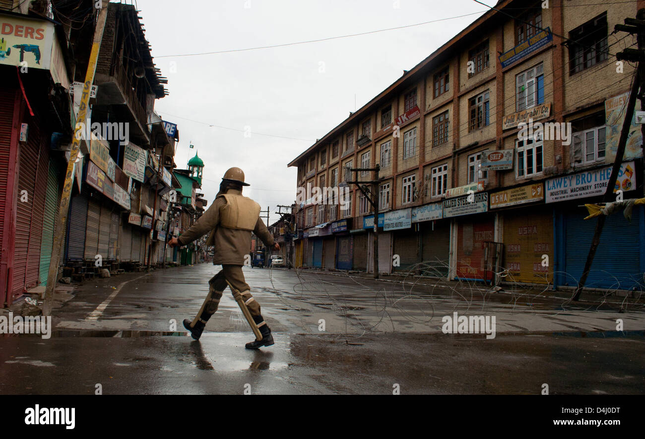 Srinagar, Indiano Kashmir amministrato, giovedì 14 marzo 2013. La polizia indiana uomo protezioni strade deserte durante un coprifuoco a Srinagar la capitale estiva di Indiano Kashmir amministrato, India. Le autorità indiane ha imposto il coprifuoco in Kashmir per contrastare la manifestazione di protesta dopo che hanno ucciso un 34 anno vecchio mercoledì. Foto di Sofi Suhail/Alamy) Foto Stock