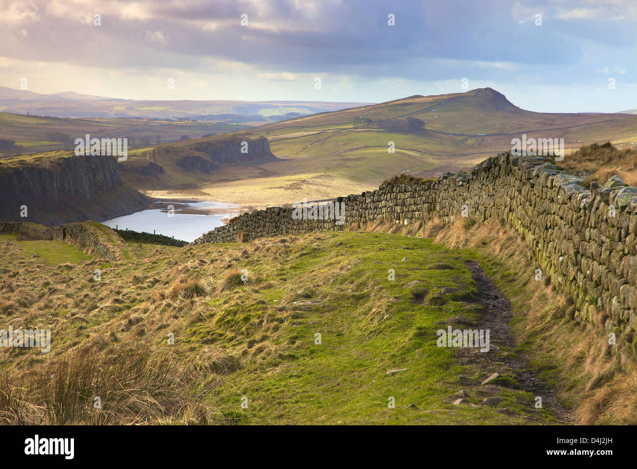 Il Vallo di Adriano dalla banca a caldo con balze Highshield sopra dirupi roccioso del Lough nella distanza Winshield Crags Northumberland Foto Stock