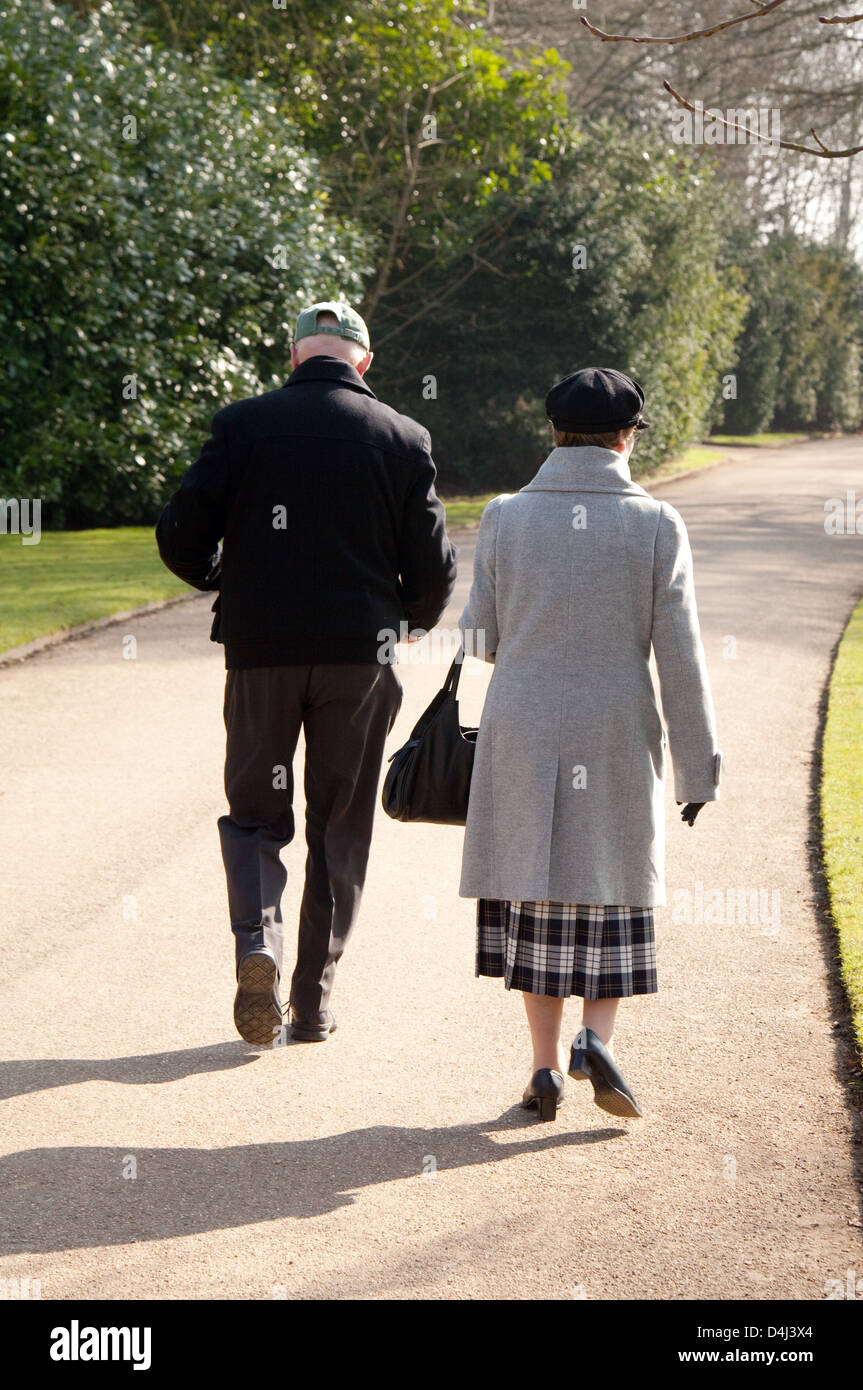 Coppia anziana, camminando nel parco dal retro, Cambridgeshire, Regno Unito Foto Stock