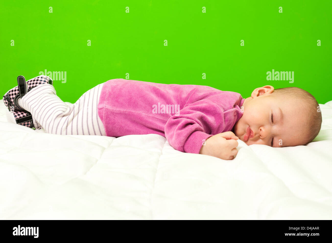 Sleeping Baby girl su la coltre bianca Foto Stock
