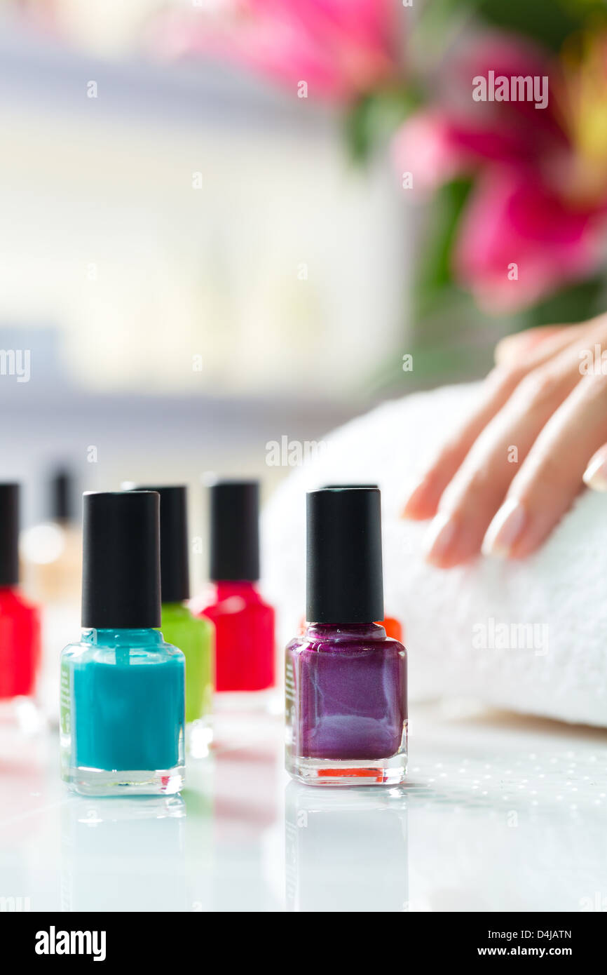 La donna in una manicure ricevendo una manicure, vi sono colorate per unghie Foto Stock