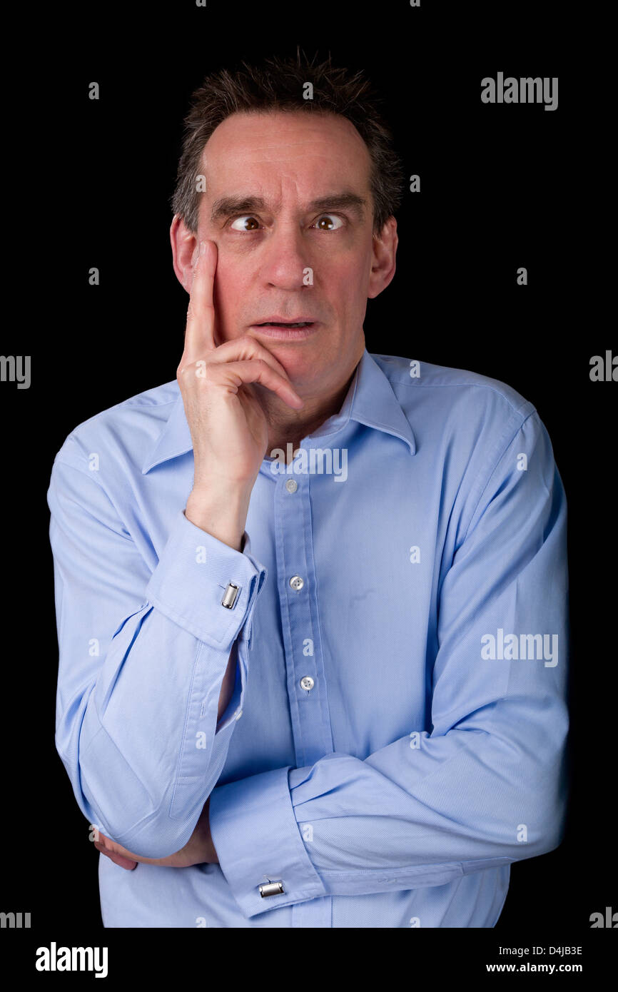 Età media Business Man tirando Funny Cross Eyed faccia Sfondo nero Foto Stock