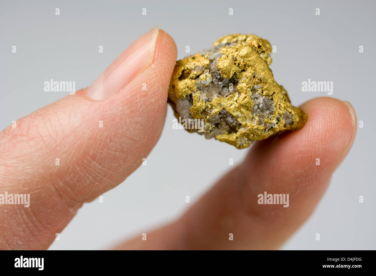 Nevada USA / oro Quartz Nugget trattenuto tra le dita Foto Stock