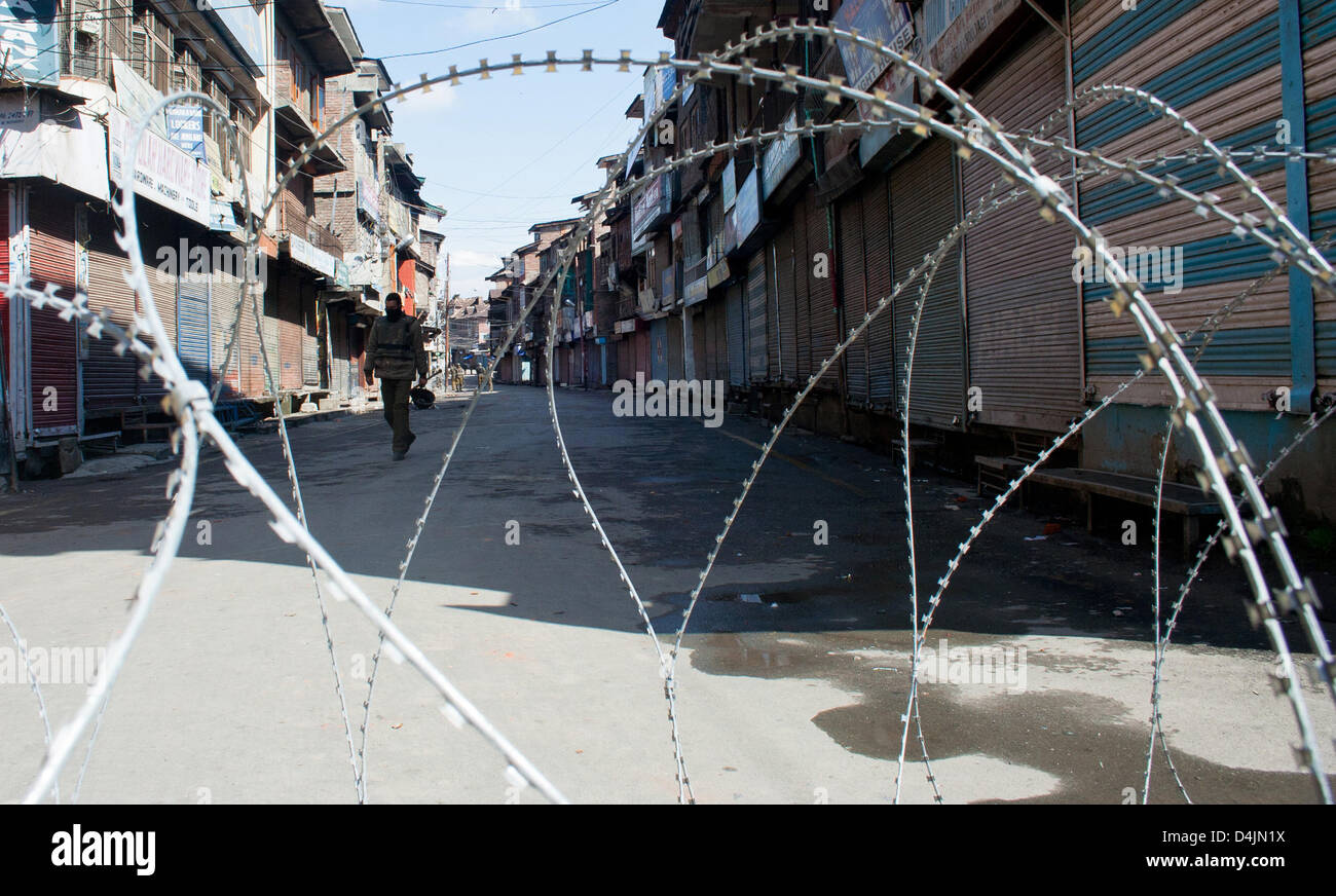 Srinagar, Indiano Kashmir amministrato. Il 15 marzo 2013. Poliziotto indiano custodisce le deserte le strade durante un coprifuoco imposto al secondo giorno consecutivo , a Srinagar la capitale estiva di Indiano Kashmir amministrato, India. Indiano coprifuoco imposto al secondo giorno consecutivo in Kashmir dopo l uccisione di cinque poliziotti paramilitari e la morte di due civili si voltò le tensioni nella tormentata regione. Credito: yawar nazir kabli / Alamy Live News Foto Stock