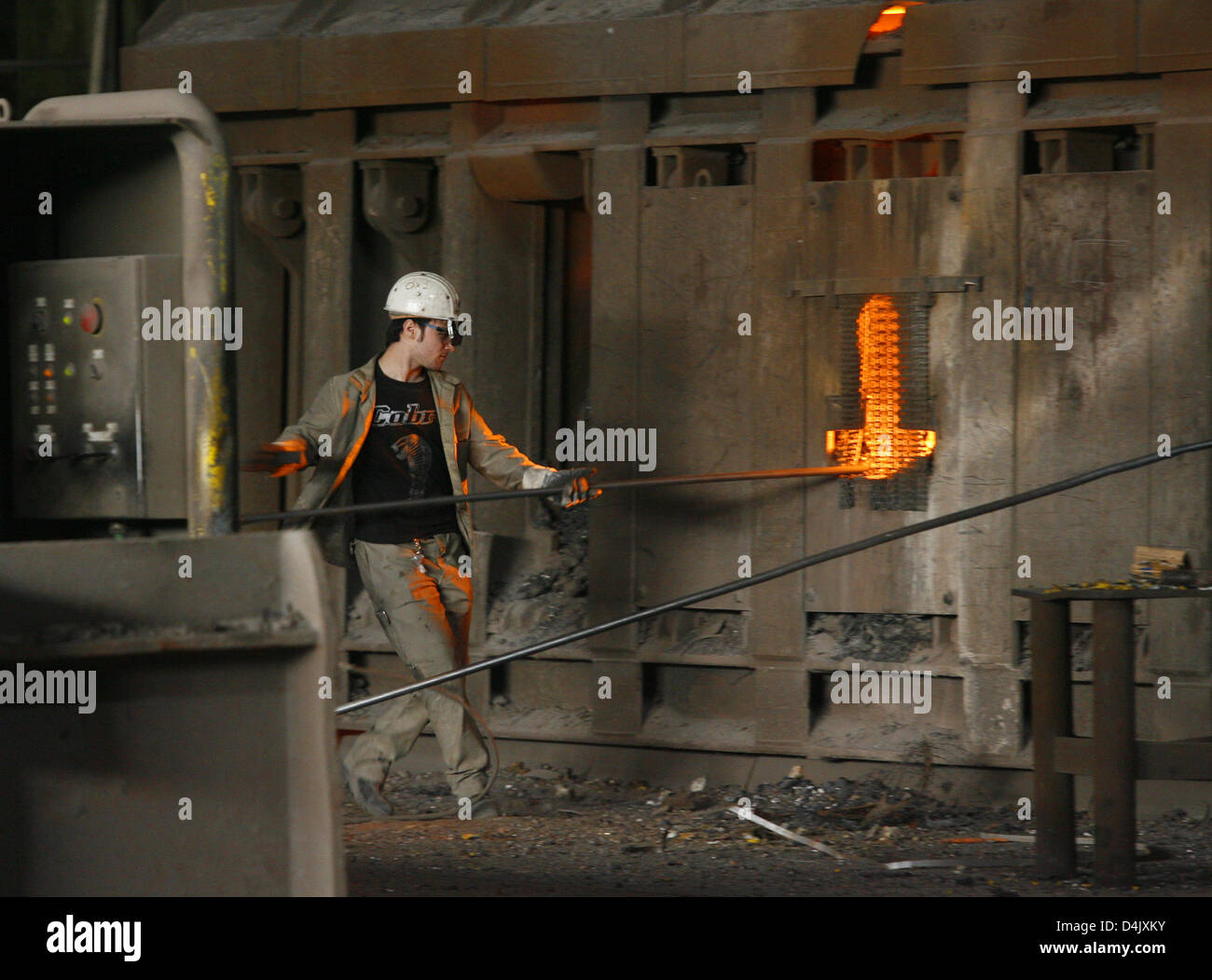 Un lavoratore in acciaio verifica la qualità di acciaio ha proceduto alla ThyssenKrupp a Duisburg, Germania, 02 marzo 2009. La ghisa è miscelato con rottami di ferro e raffinato con ossigeno per acciaio. Dall'acciaio lastre sono inoltre proceduto a bobine e fogli sottili usati a.o. nell'industria automobilistica. Foto: Roland Weihrauch Foto Stock