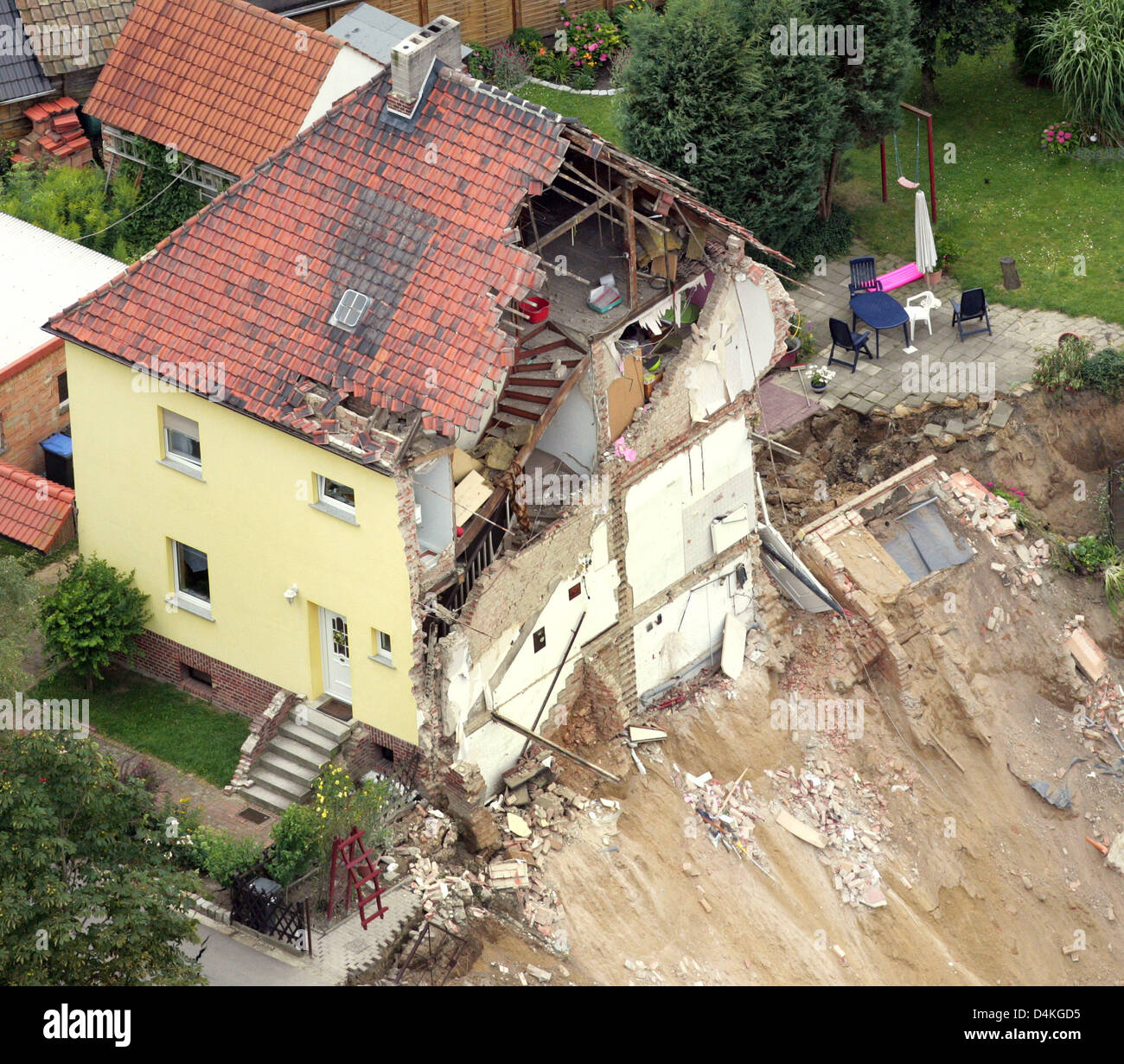 Vista sulla restante metà di una casa dopo l'altro è stato inghiottito da una frana nel Nachterstedt, Germania, 20 luglio 2009. Tre i residenti sono scomparsi dopo la loro casa in riva al lago e un altro edificio è crollato improvvisamente in acqua il 18 luglio. A 350 metri di tratto di litorale ha dato modo accanto a un vecchio a cielo aperto della miniera di carbone convertito in un lago. Due giorni dopo il disastro, esperti di Foto Stock