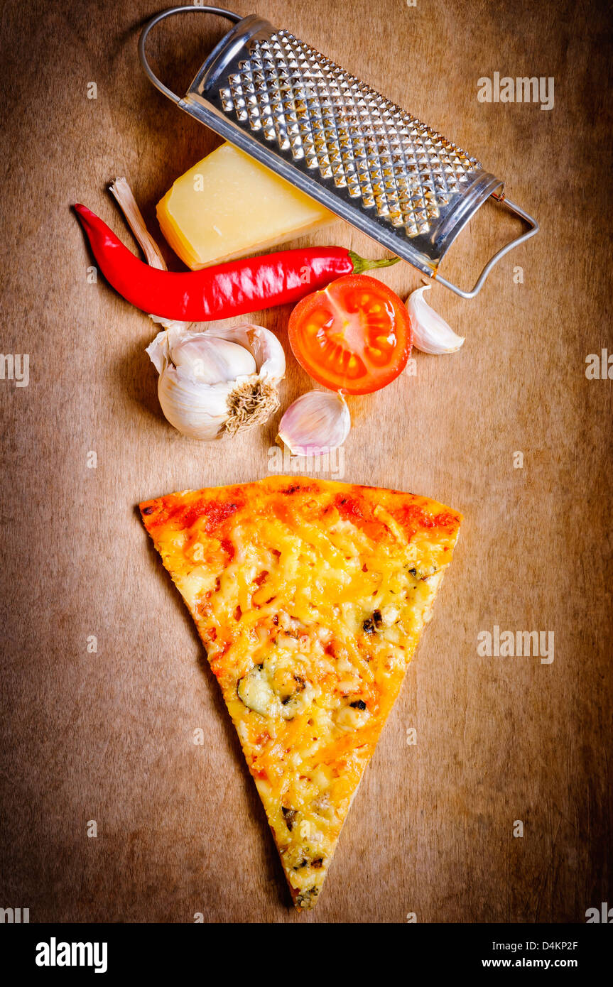Formaggio trancio di pizza con gli ingredienti alimentari su uno sfondo di legno Foto Stock