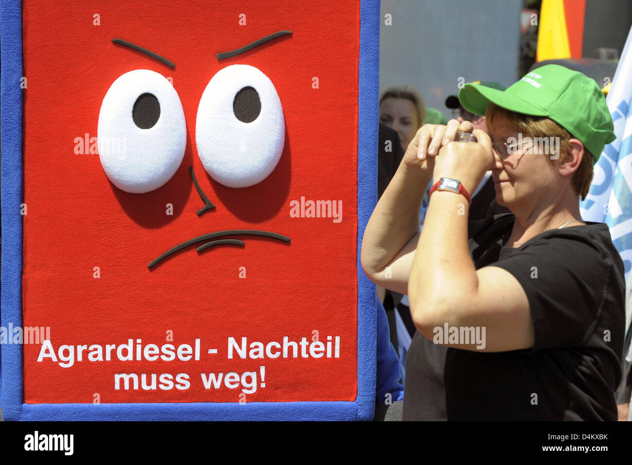 Un partecipante del rally di protesta contro la politica agraria del governo federale prende le immagini accanto a una figura con un testo che legge ?Il agrodiesel svantaggio deve essere abolito? A Berlino, Germania, 25 maggio 2009. 600 agricoltori ha spinto per la Colonna della Vittoria con i loro trattori per poter prendere parte al rally della tedesca degli agricoltori? L'associazione. Foto: Soeren Stache Foto Stock