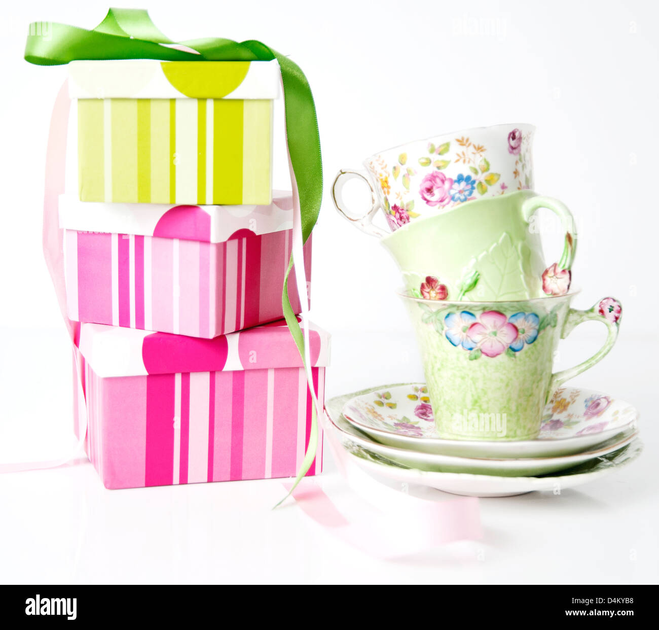 Colorato dono scatole impilate fino a fianco impilati tazze di tè Foto Stock