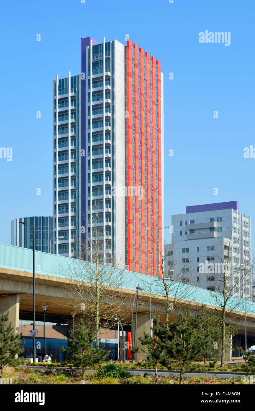 Alto e moderno blocco di appartamenti costruito accanto alla strada principale sopraelevata Foto Stock