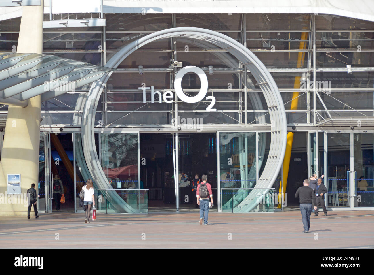 Persone all'edificio polifunzionale dell'arena al coperto O2 e ingresso con grande logo presso la Millennium Dome North Greenwich Peninsula Londra Inghilterra Regno Unito Foto Stock