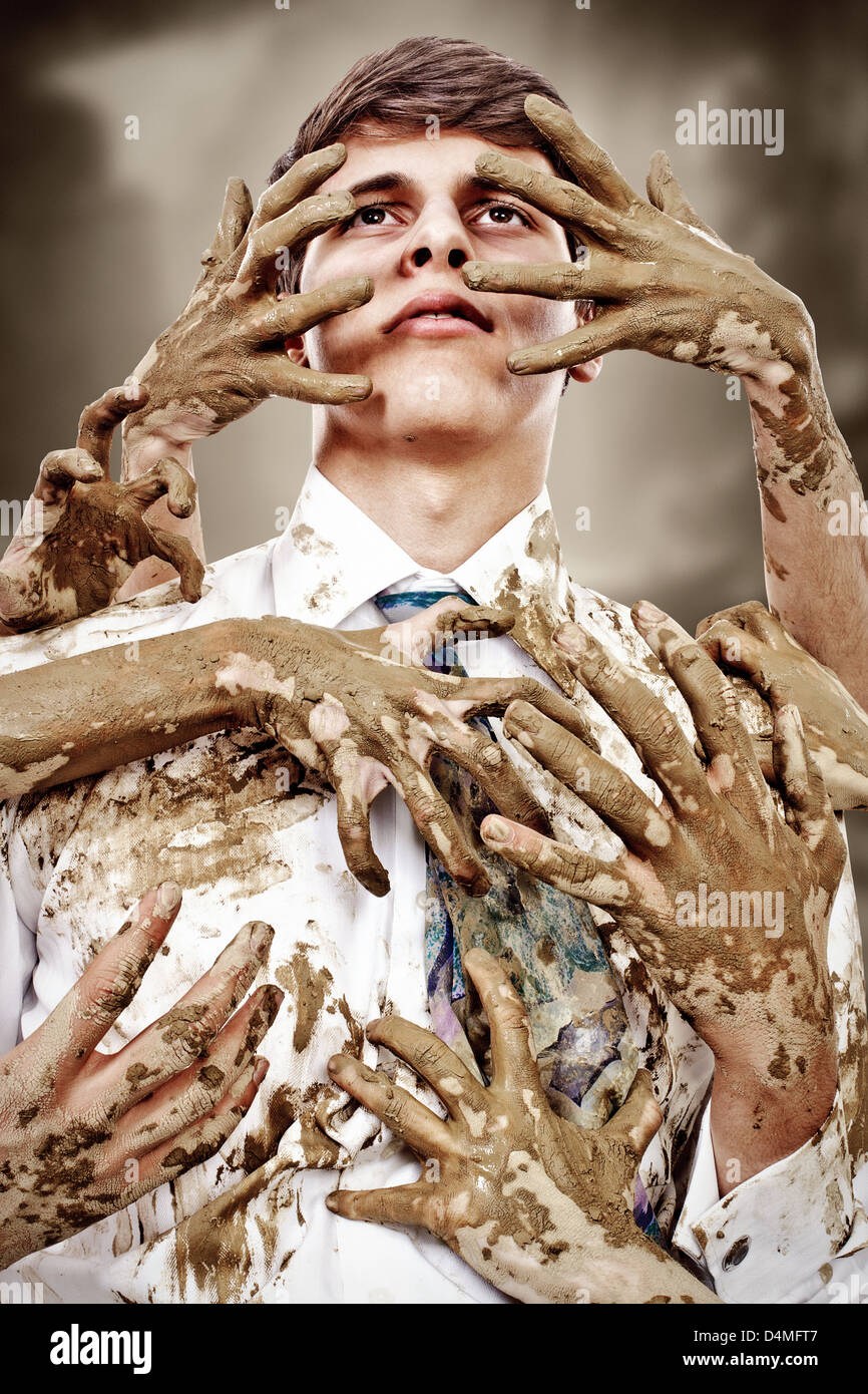 Giovane uomo macchiata dalla moltitudine di mani sporche Foto Stock