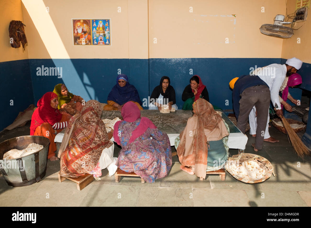 Un gruppo di donne chapattis impilamento nella libera di cucina presso il Tempio d'Oro Amritsar Punjab India Foto Stock