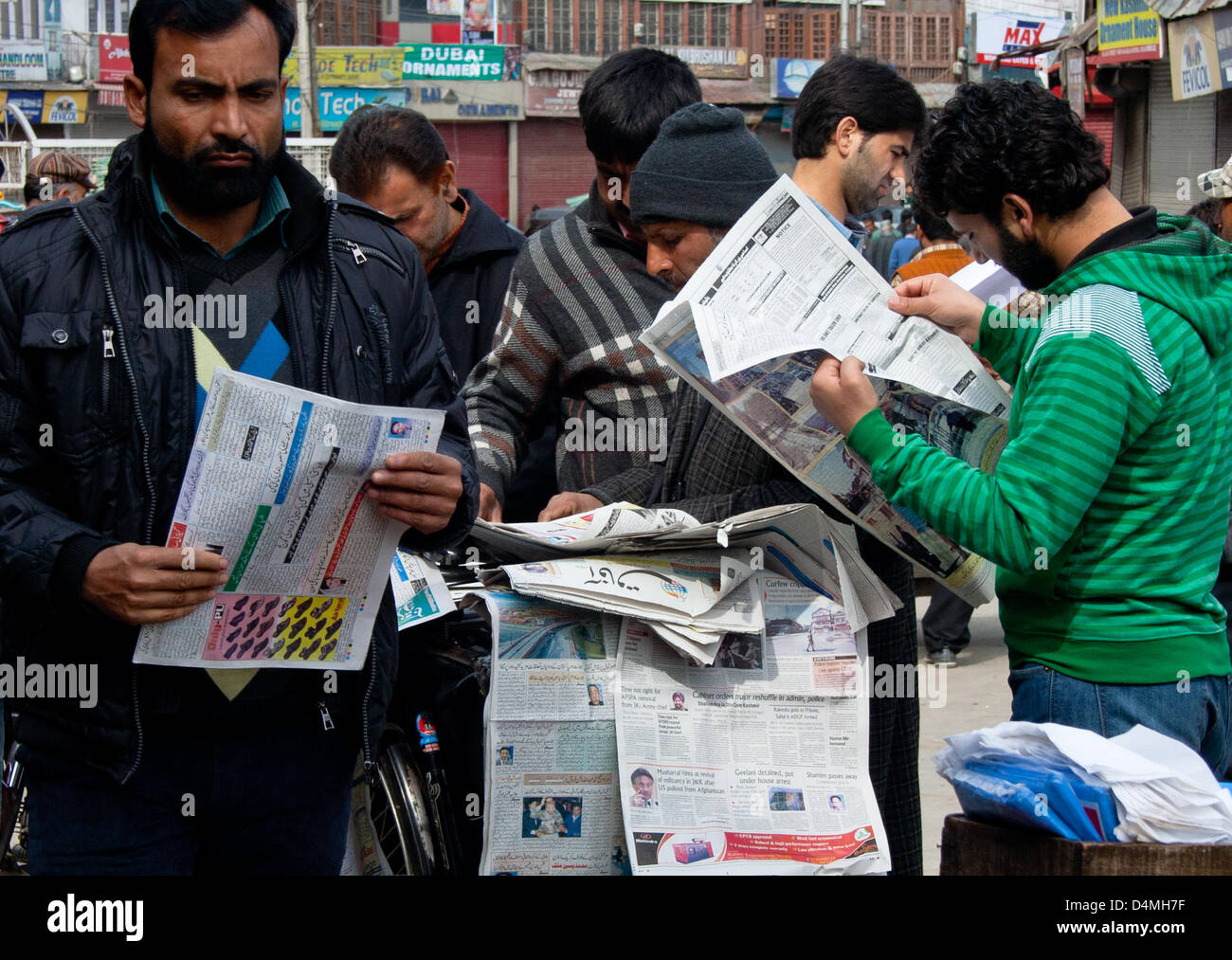 Srinagar, Indiano Kashmir amministrato, sabato 16 marzo 2013. La gente compra i giornali da un Hawker dopo un rilassamento in coprifuoco a Srinagar . La vita normale rimane influenzato in indiano-Kashmir amministrato tuttavia le autorità indiane sollevato coprifuoco da molte parti del Kashmir, che era stato messo sotto un rigido coprifuoco per molti giorni preoccupato di massicce proteste dell'opinione pubblica in seguito all' uccisione di civili del Kashmir. (Yawar Nazir Kabli/ Alamy) Foto Stock