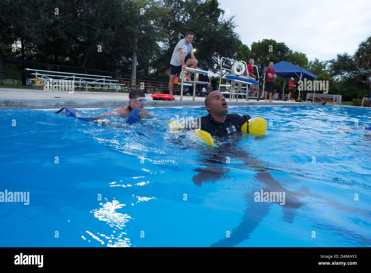 Un membro della Guardia Costiera implementa un dispositivo galleggiante come parte di un esercizio di sopravvivenza in acqua durante il programma "Week in the Life". Questo scenario dimostra la prontezza della Guardia Costiera per la risposta di emergenza e l'addestramento di squadre specializzate, tra cui il cane estraibile e le unità tattiche nelle operazioni di sicurezza e sopravvivenza in acqua. Foto Stock