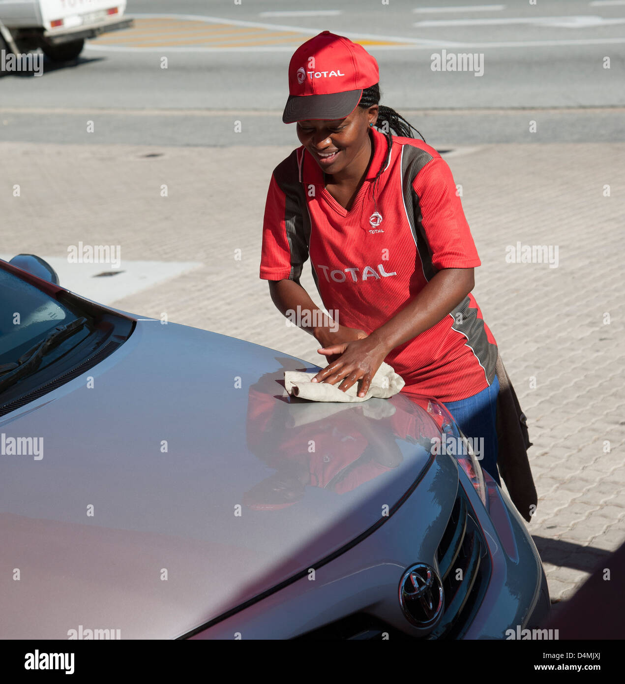 Southern African lavoratrice dipendente che lavora la lucidatura auto cofano Foto Stock