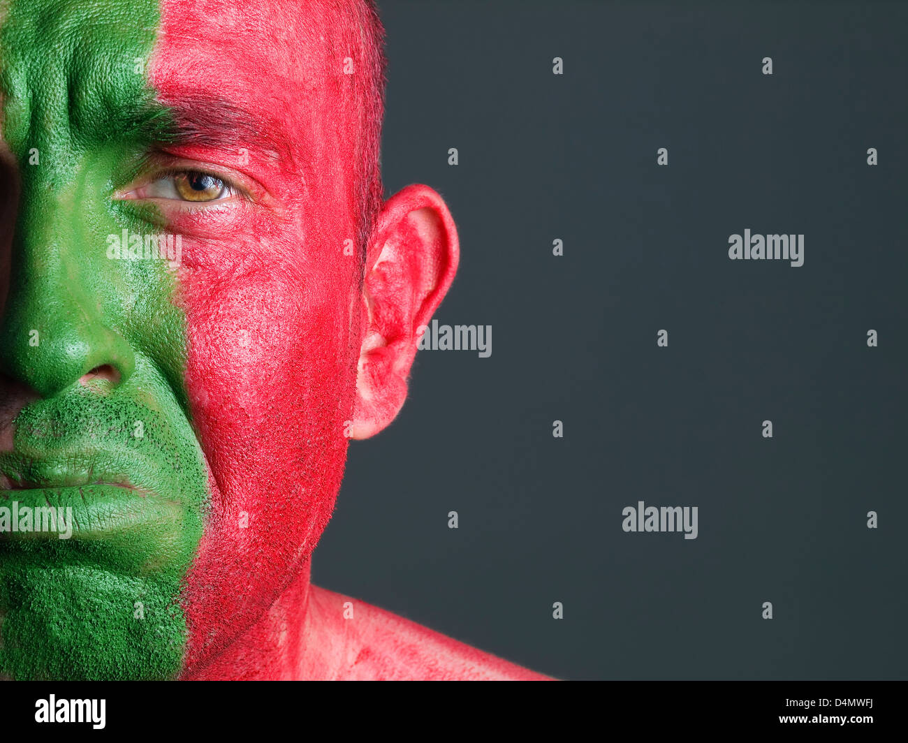 L'uomo con il suo volto dipinto con la bandiera del Portogallo. L'uomo è triste e composizione fotografica lascia solo metà della faccia. Foto Stock