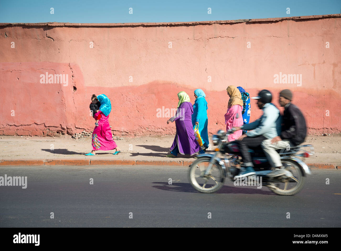 Donna araba a piedi giù per la strada in abiti colorati Foto Stock