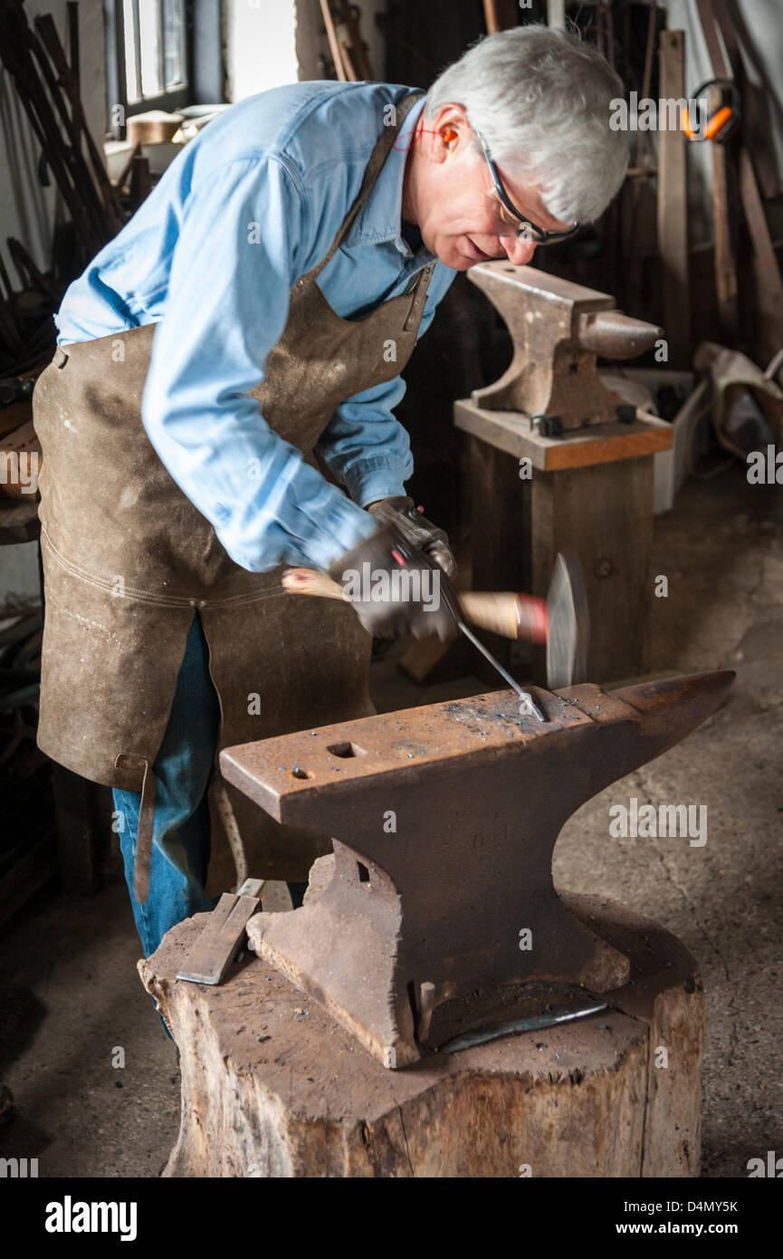 Thriplow Daffodil Weekend, Cambridgeshire, Regno Unito. Sabato 16 marzo 2013. Un fabbro dimostra abilità tradizionali nel vecchio fabbri forge. La vecchia fucina era ancora aperto negli anni Sessanta ed è oggi un museo. Vento freddo e pioggia non ha impedito il festival annuale che è frequentato da migliaia di visitatori e continua domani. La manifestazione è organizzata dall'Daffodil Weekend fiducia e raccoglie fondi per una diversa carità ogni anno. Credito: Julian Eales / Alamy Live News Foto Stock Thriplow Daffodil Weekend, Cambridgeshire, Regno Unito. Sabato 16 marzo 2013. Un fabbro dimostra abilità tradizionali nel vecchio fabbri forge. La vecchia fucina era ancora aperto negli anni Sessanta ed è oggi un museo. Vento freddo e pioggia non ha impedito il festival annuale che è frequentato da migliaia di visitatori e continua domani. La manifestazione è organizzata dall'Daffodil Weekend fiducia e raccoglie fondi per una diversa carità ogni anno. Credito: Julian Eales / Alamy Live News Foto Stock