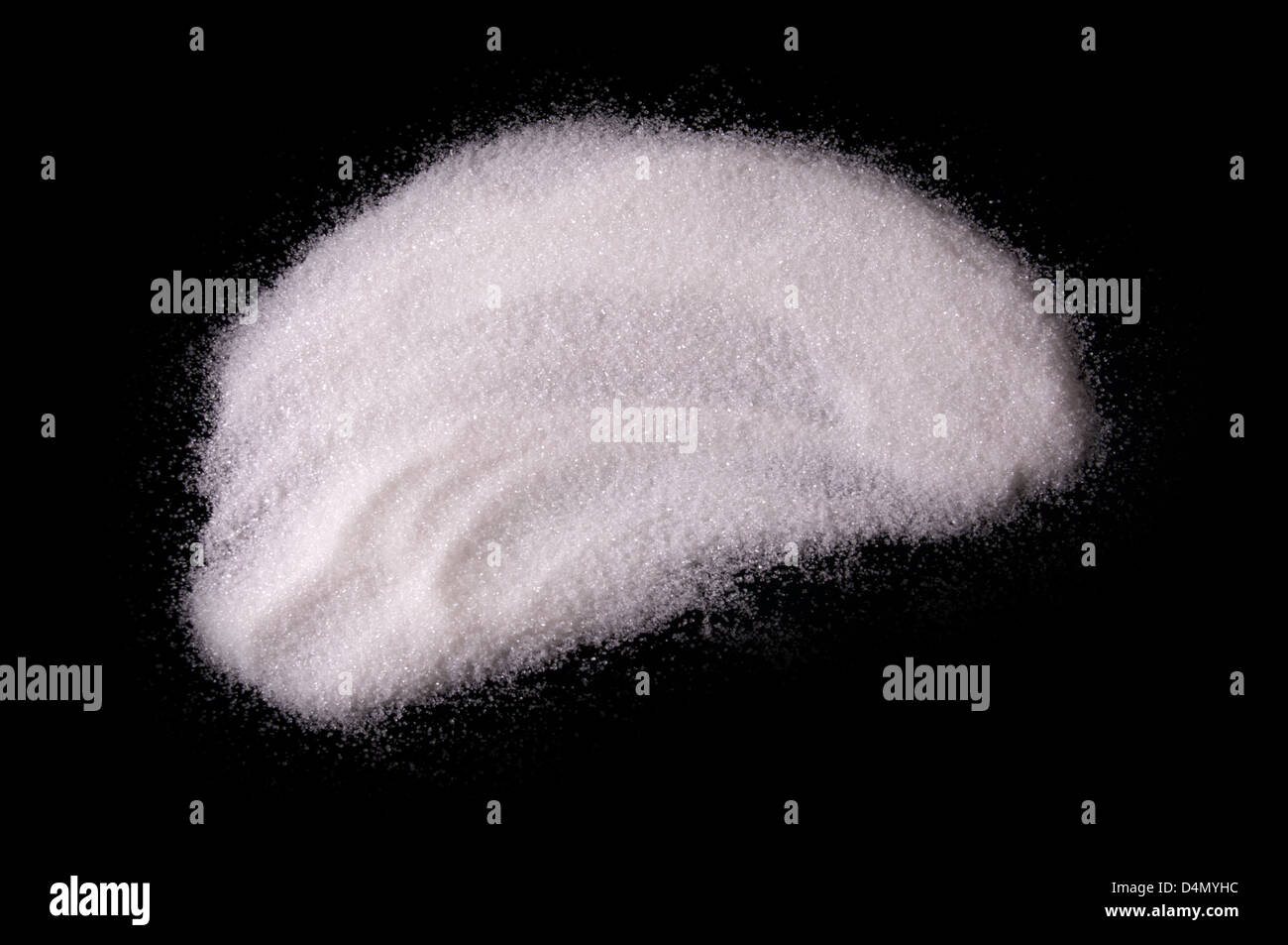 Bianco zucchero chrystals polvere su sfondo nero Foto Stock