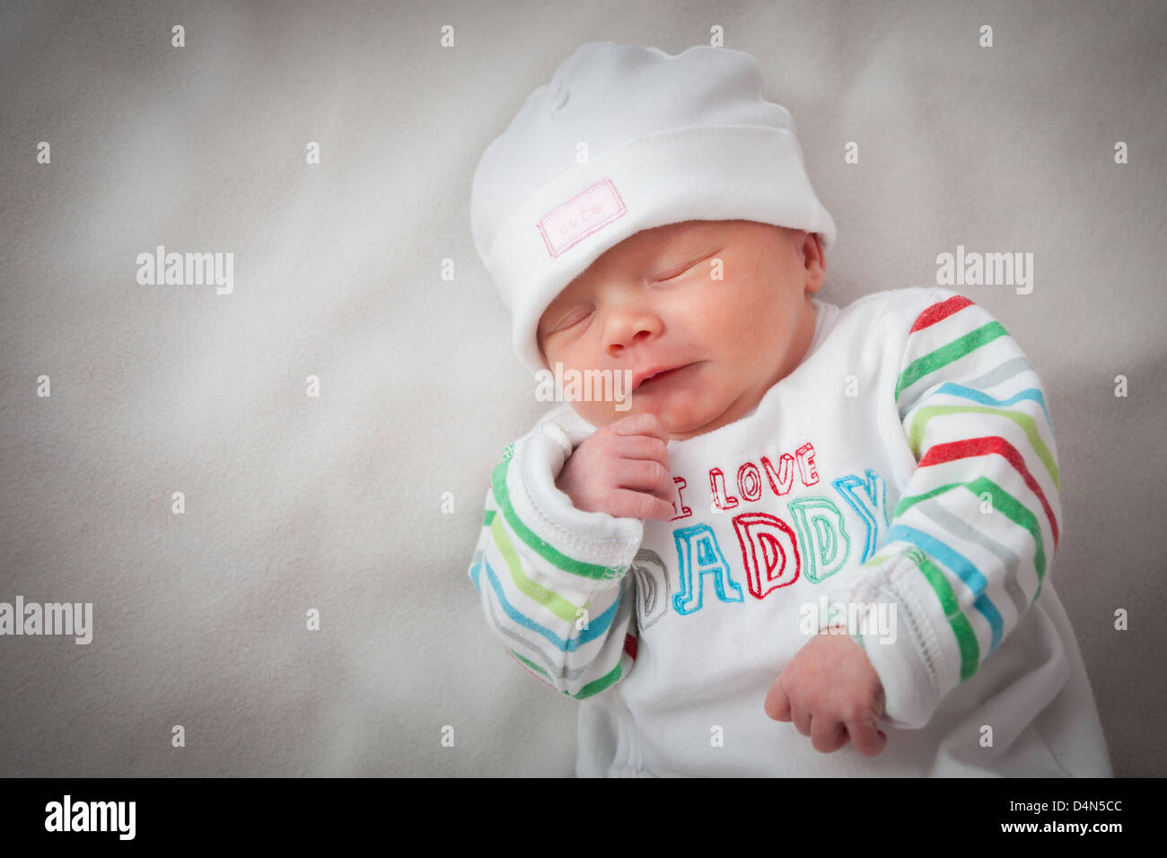 Baby girl (8 giorni) prese in un soffice luce (luce tenda). Hat leggere "carino" e top legge 'I love Daddy'. Foto Stock