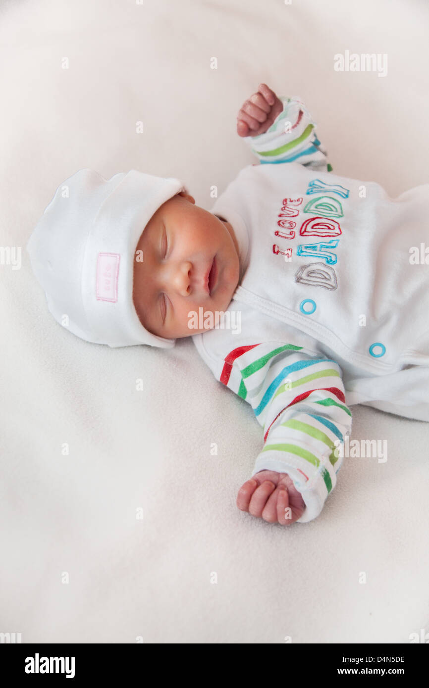 Baby girl (8 giorni) prese in un soffice luce (luce tenda). Hat legge "carino" e top legge 'I love Daddy'. Foto Stock
