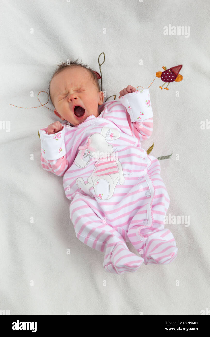 Bella sbadigli neonato ragazza (6 giorni) prese in un soffice luce (luce tenda) su un morbido manto. Foto Stock