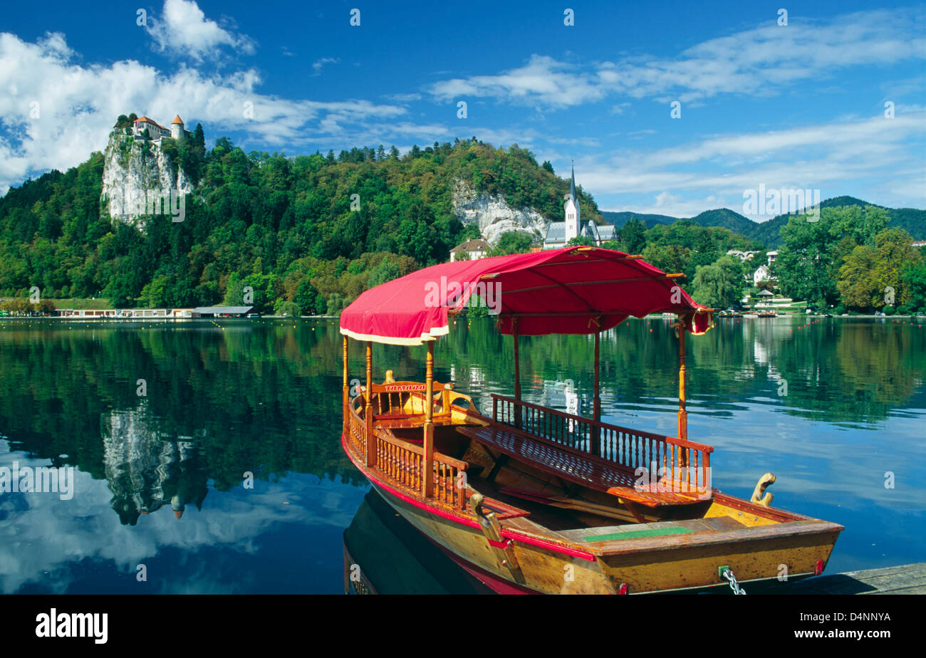 Una barca Pletna sul lago di Bled e del Castello di Bled, Gorenjska, Slovenia. Foto Stock