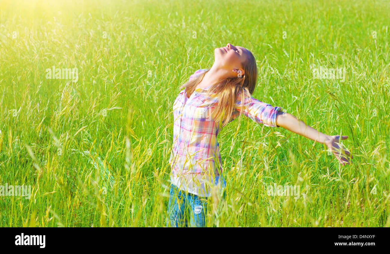 Donna con divertimento all'aperto, godendo di aria fresca e la molla verde erba, la libertà e la felicità concept Foto Stock