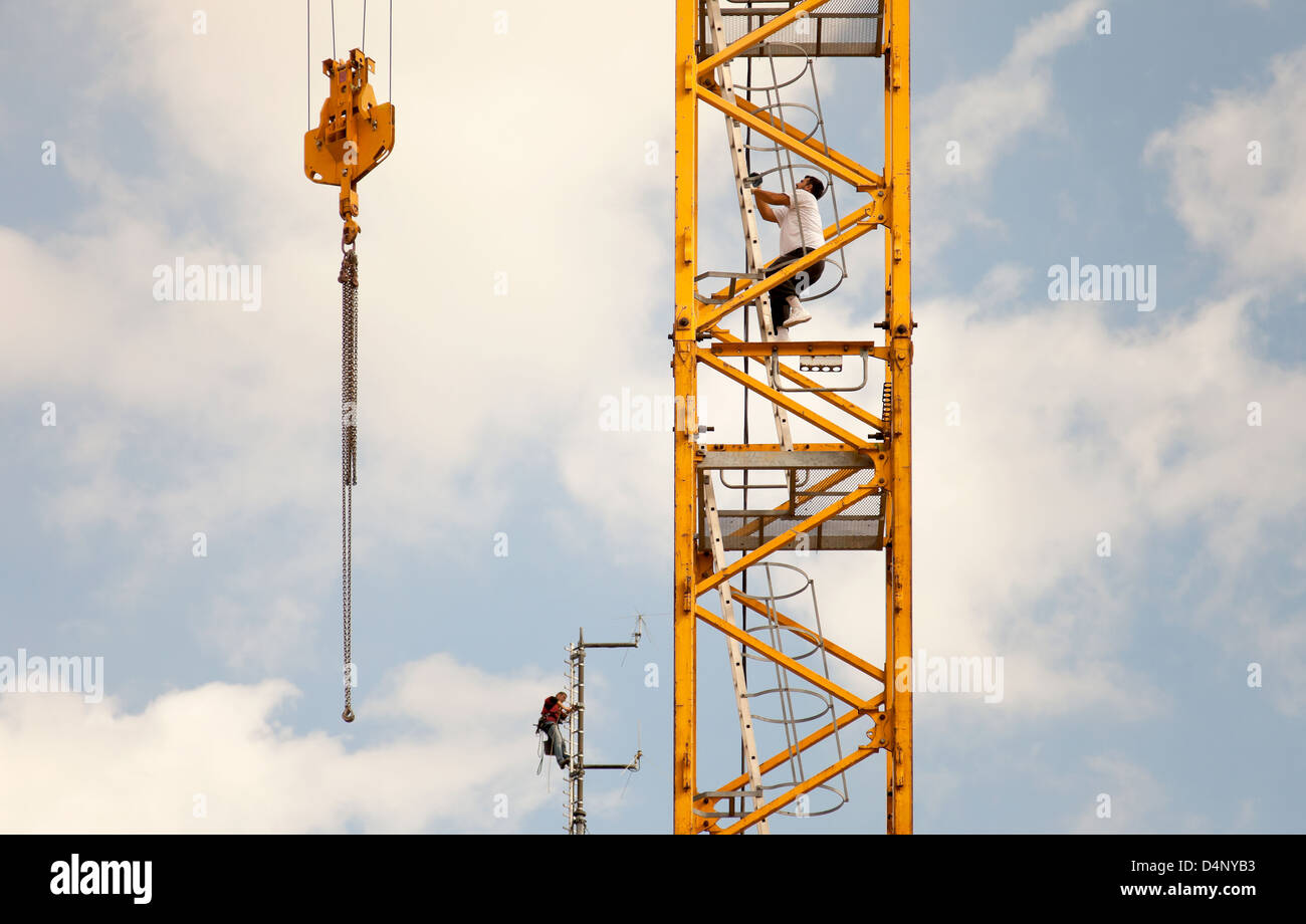 Berlino, Germania, un operatore della gru e un meccanico ad una vertiginosa altezza Foto Stock