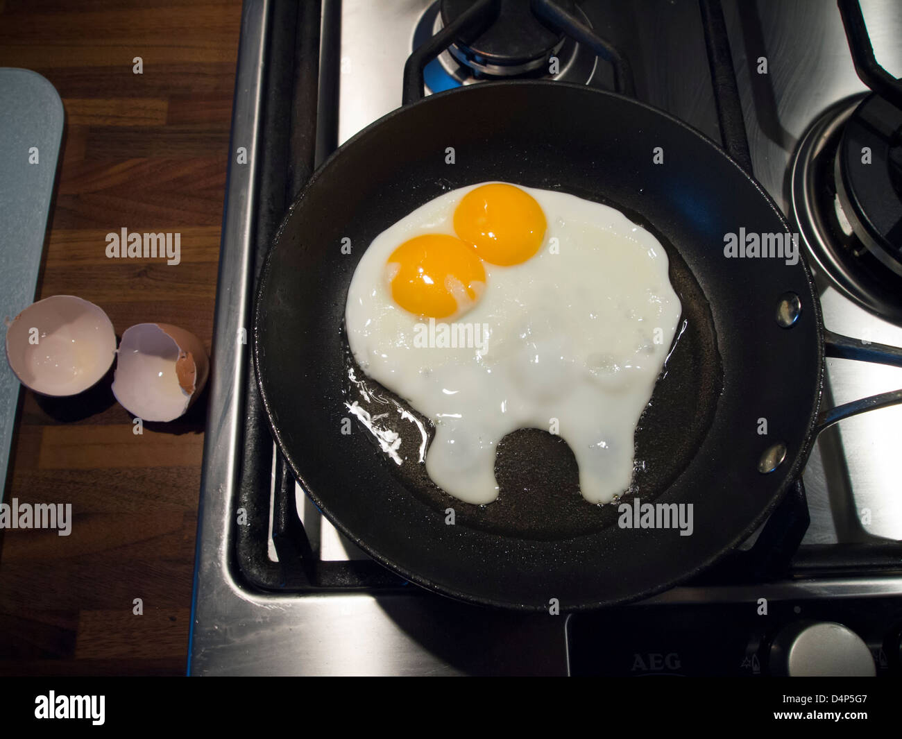 Un uovo con doppio tuorli friggere in una padella. Foto Stock