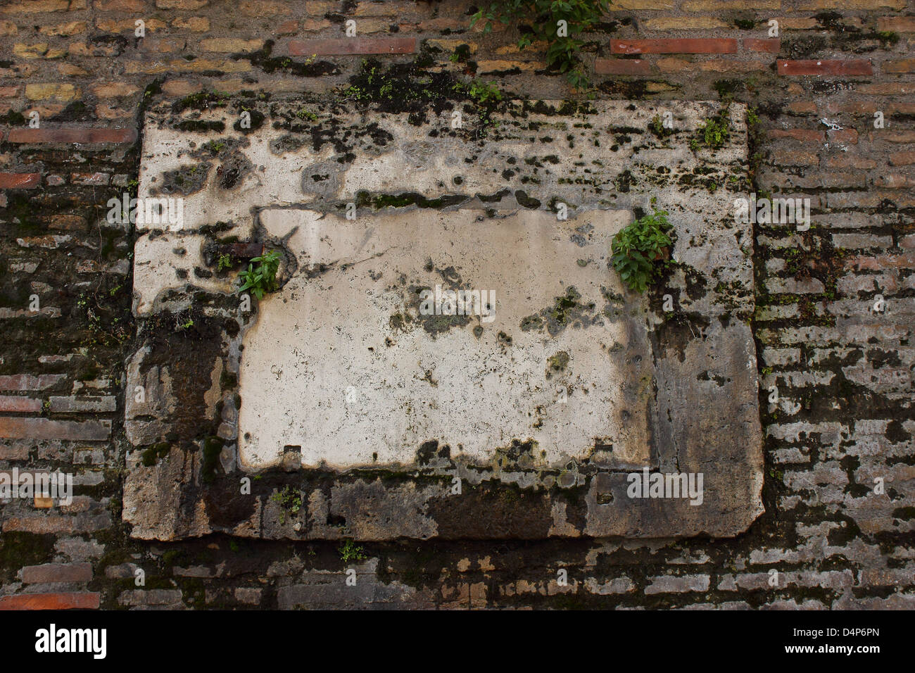 Antica cornice marmorea su un muro in mattoni del Vaticano Foto Stock