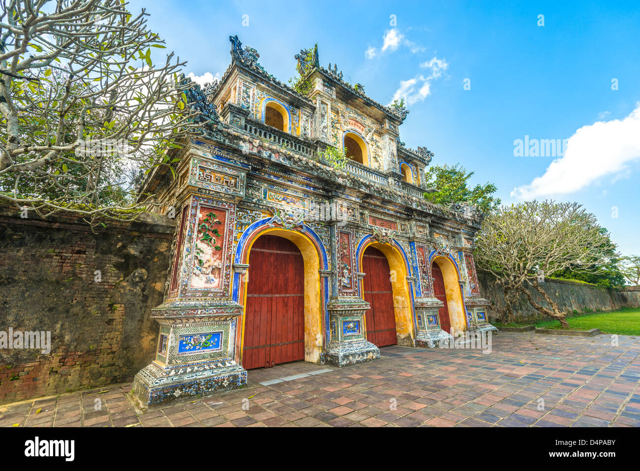 La facciata della porta la cittadella di Hue, Vietnam, in Asia. Ingresso ornato di Hue città imperiale. Bright day con il blu del cielo e il verde erba. Tr Foto Stock